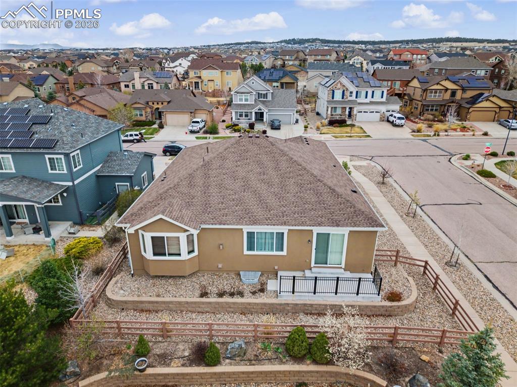 Image 5 of 40: Back of property featuring stucco siding, a shingled roof, a fenced backyar