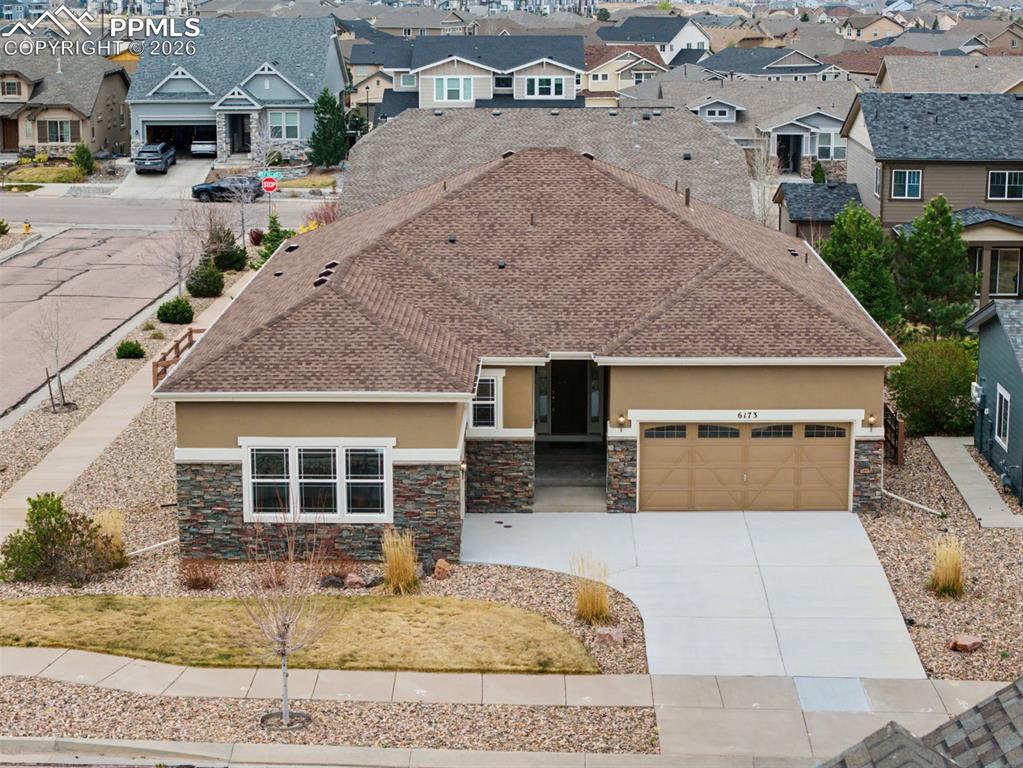 Image 7 of 40: View of front facade with stucco siding, driveway, a shingled roof, and a r