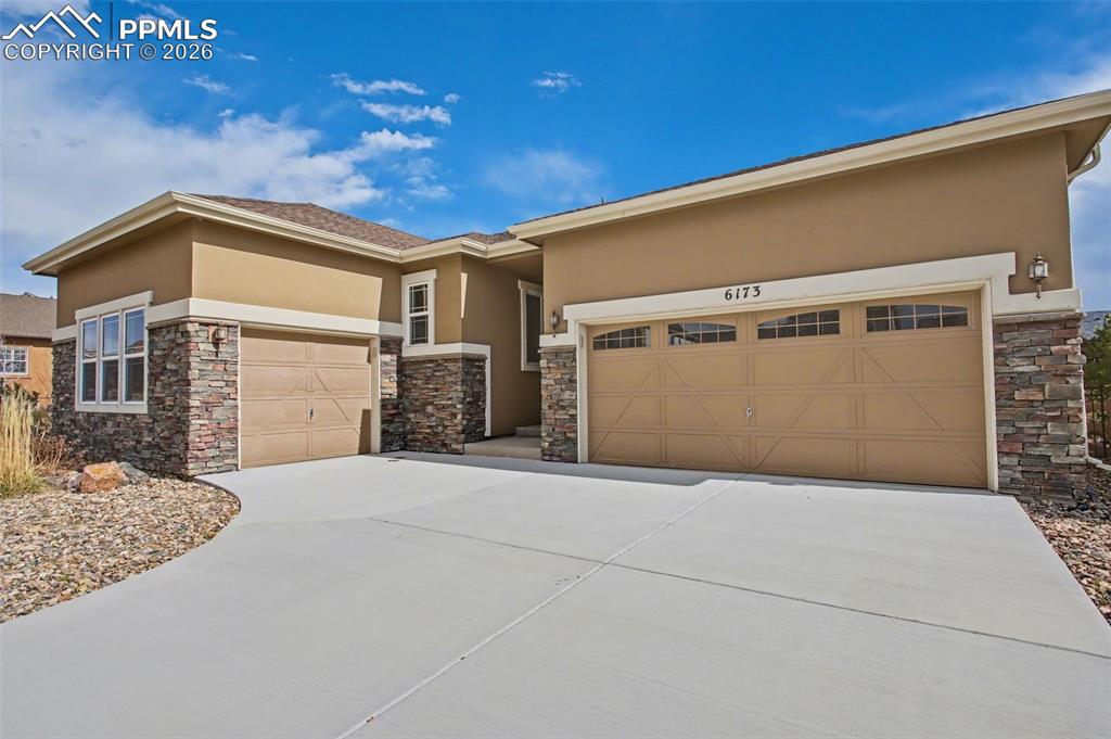 Image 8 of 40: Prairie-style house featuring stucco siding, stone siding, concrete drivewa