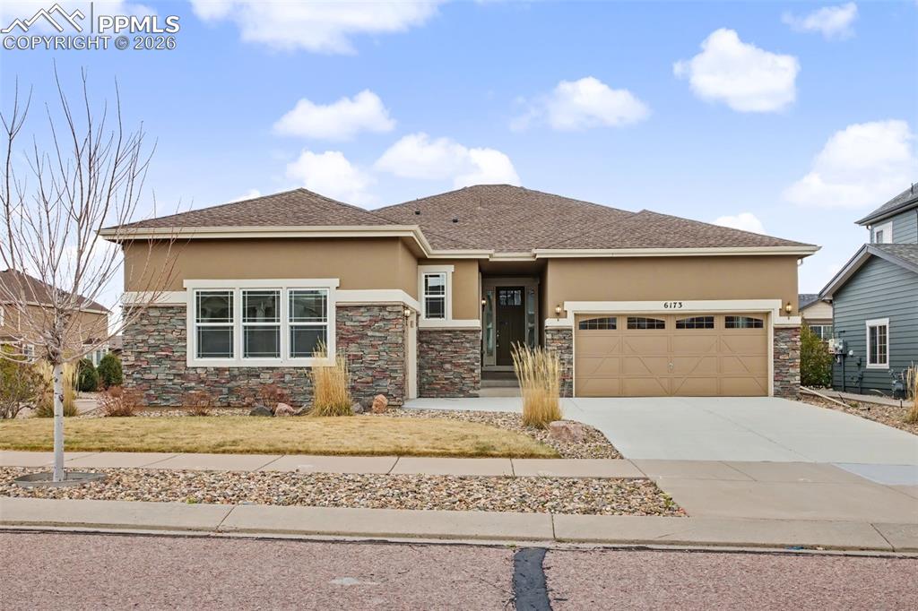 Image 9 of 40: Prairie-style home with stucco siding, concrete driveway, a garage, a shing