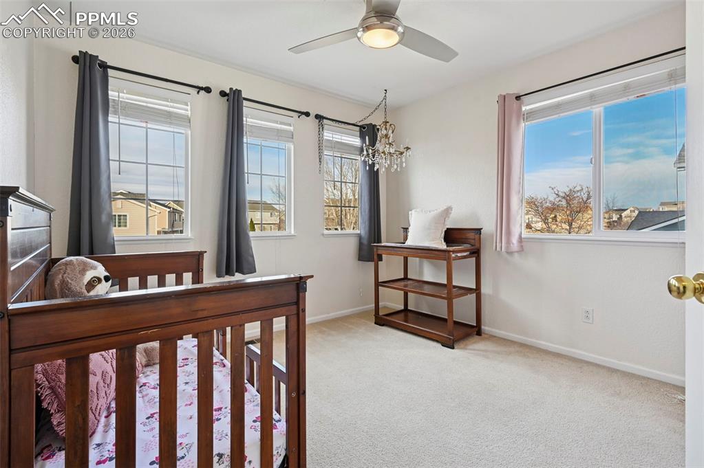 Image 26 of 49: Upstairs, bedroom 2 with west-facing windows and Pikes Peak Views