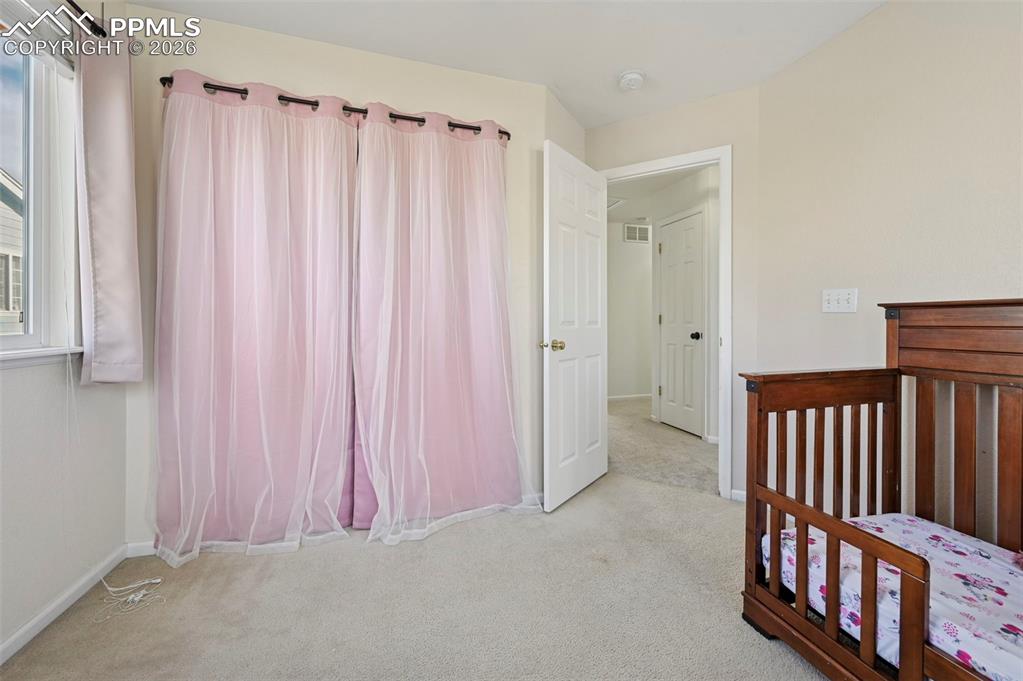 Image 27 of 49: Upstairs, bedroom 2 with west-facing windows and Pikes Peak Views