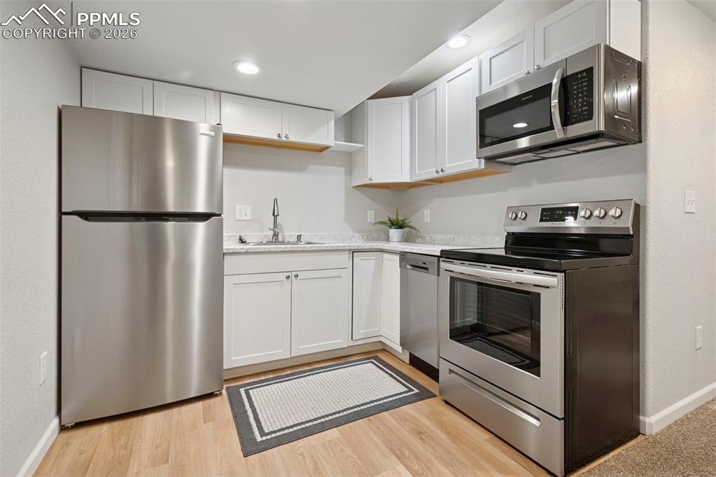 Image 33 of 49: Downstairs kitchenette with sink, refrigerator, oven, dishwasher and microw