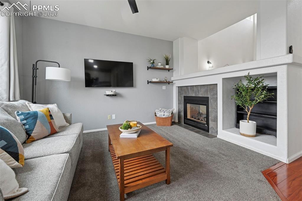 Image 7 of 49: Family room, large picture window, double-sided fireplace, carpet, adjoins 