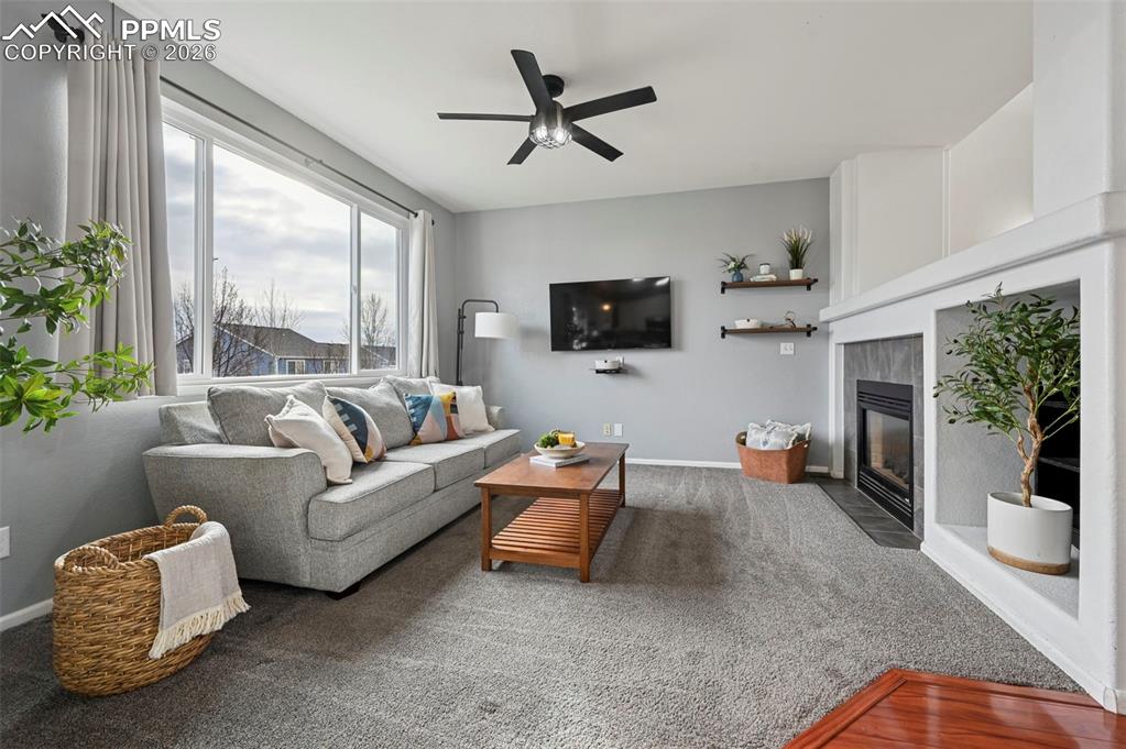 Image 8 of 49: Family room, large picture window, double-sided fireplace, carpet, adjoins 