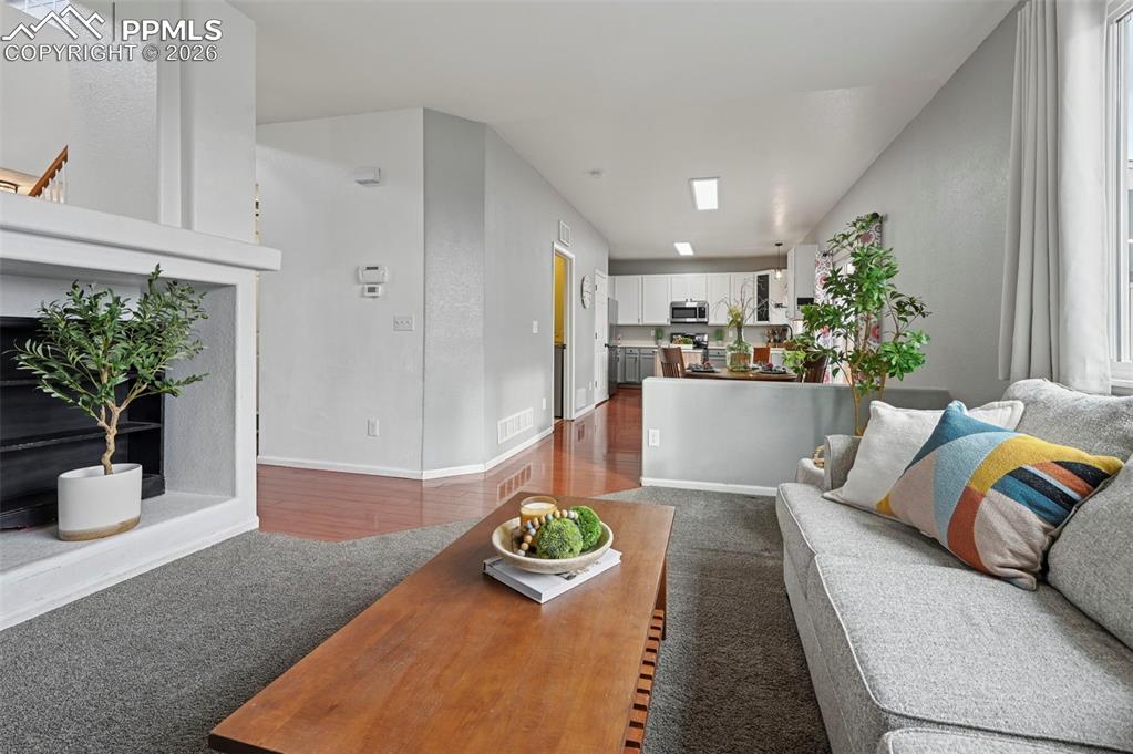 Image 9 of 49: Family room, large picture window, double-sided fireplace, carpet, adjoins 