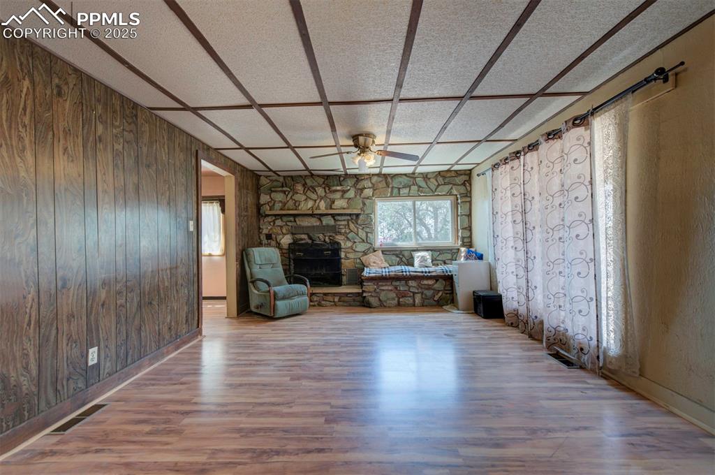 Image 7 of 22: Wood burning fireplace in living room.