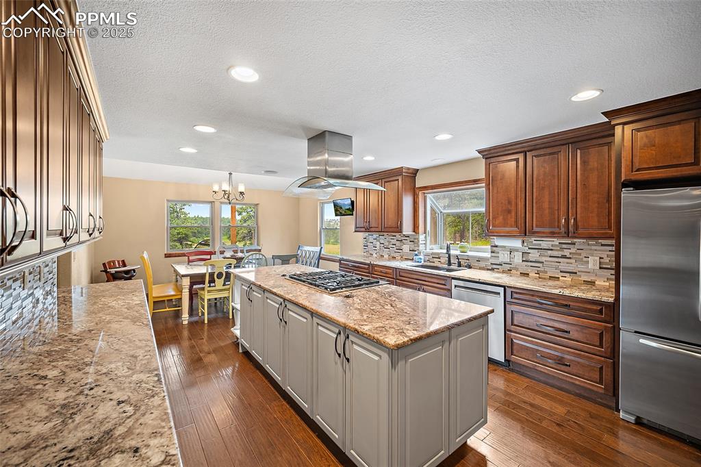 Image 14 of 47: Kitchen featuring decorative backsplash, stainless steel appliances, a kitc