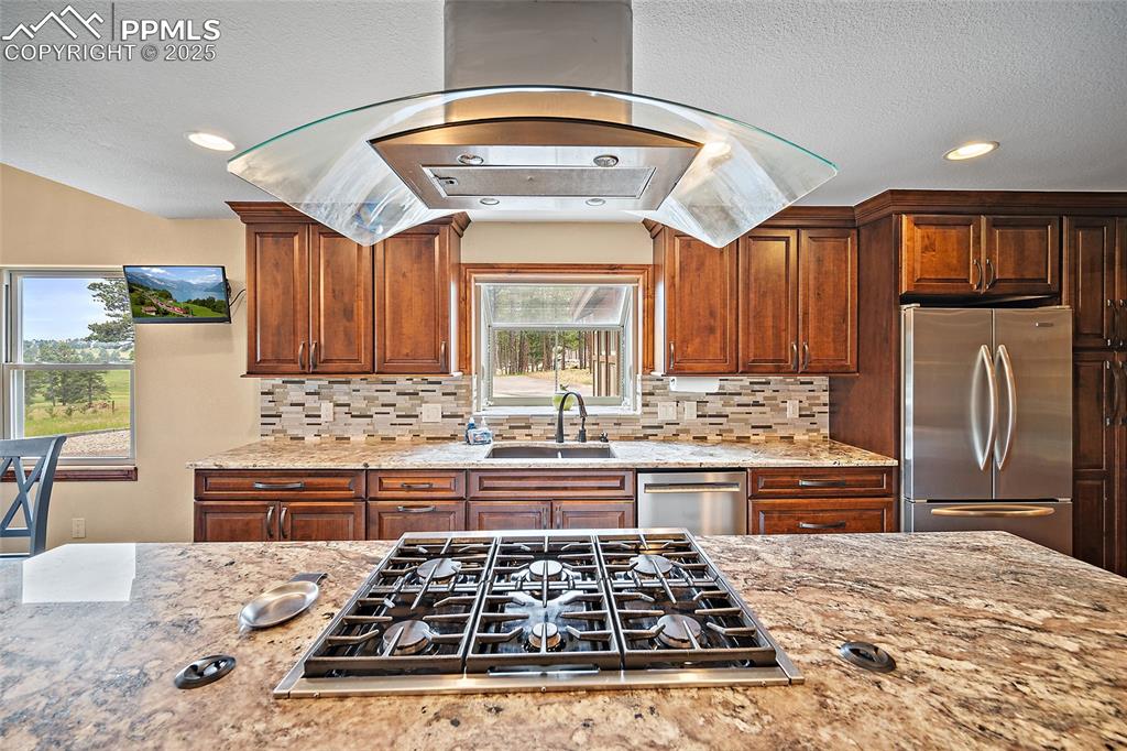 Image 15 of 47: Kitchen with exhaust hood, appliances with stainless steel finishes, tastef