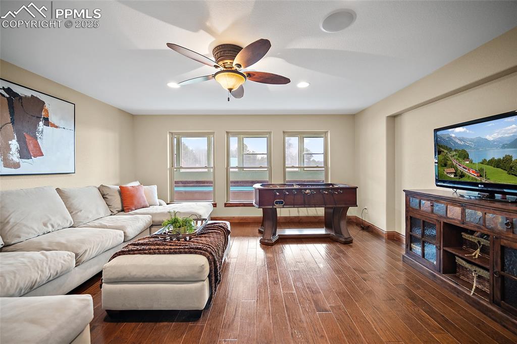 Image 17 of 47: Living area with dark wood-type flooring, ceiling fan, and recessed lightin