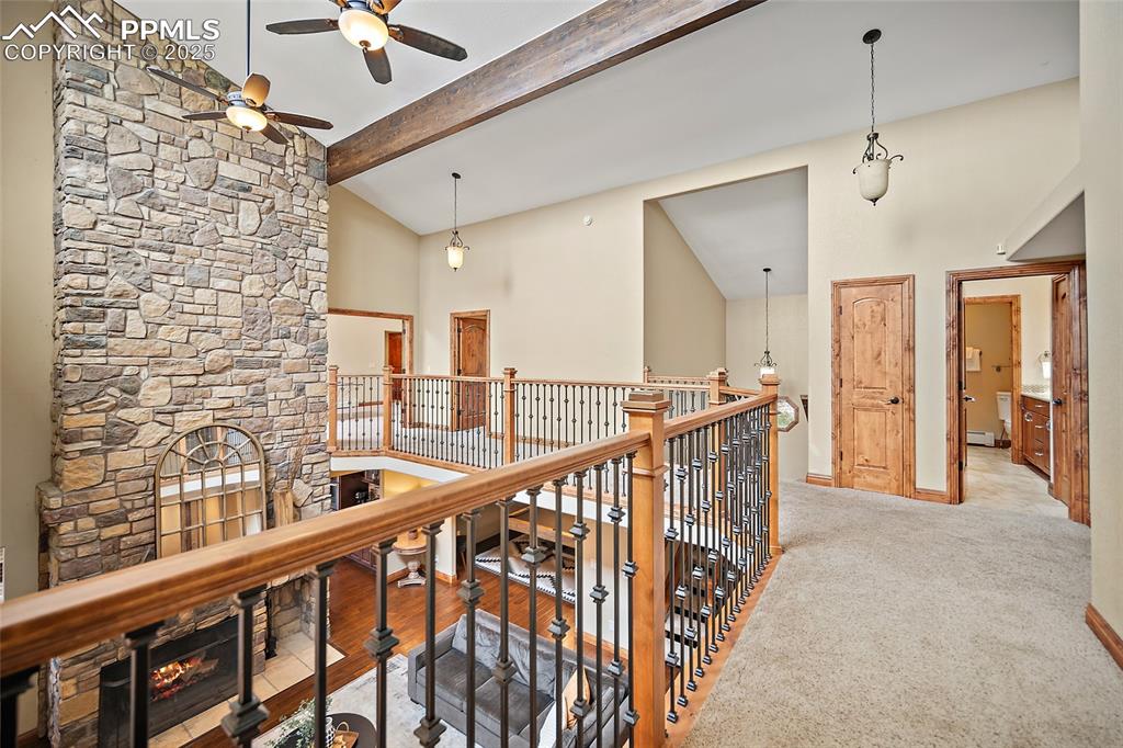 Image 26 of 47: Hallway featuring high vaulted ceiling, beam ceiling, carpet, an upstairs l