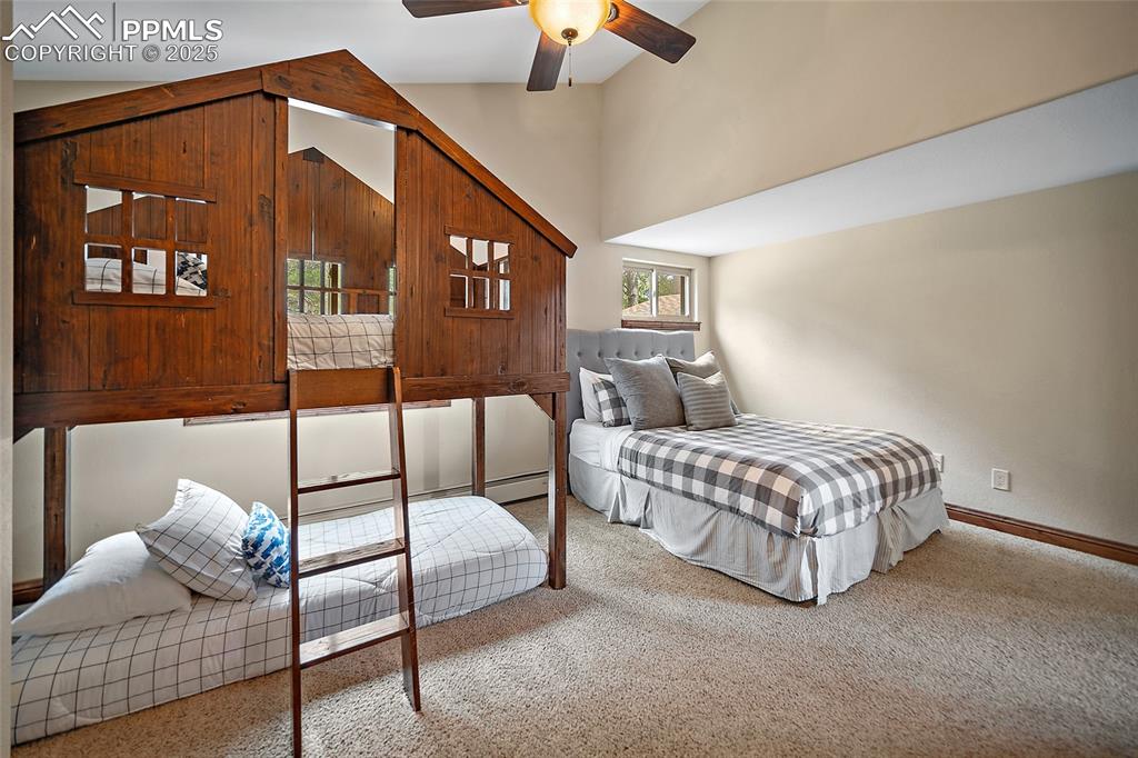 Image 27 of 47: Carpeted bedroom featuring high vaulted ceiling and a ceiling fan