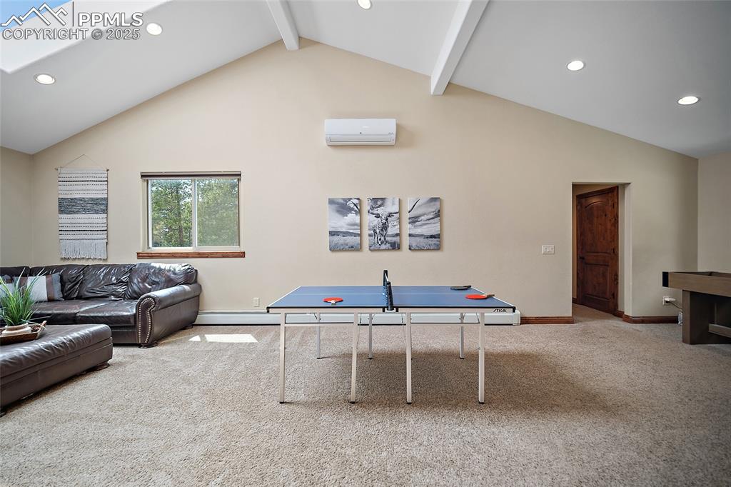 Image 32 of 47: Rec room featuring recessed lighting, carpet floors, beamed ceiling, a skyl