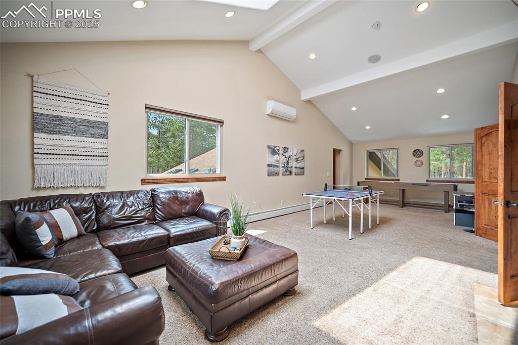 Image 33 of 47: Living room with beamed ceiling, healthy amount of natural light, carpet, r