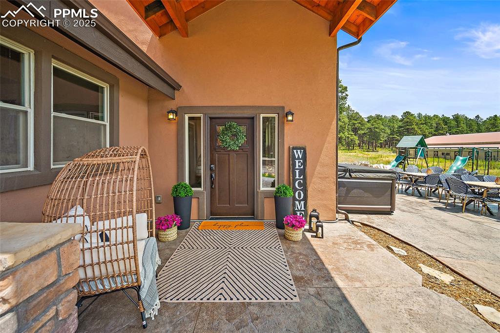 Image 4 of 47: Doorway to property featuring stucco siding