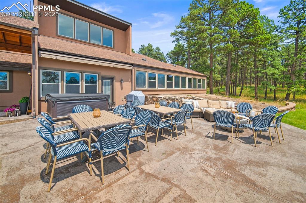 Image 40 of 47: View of patio featuring a hot tub, an outdoor living space, outdoor dining