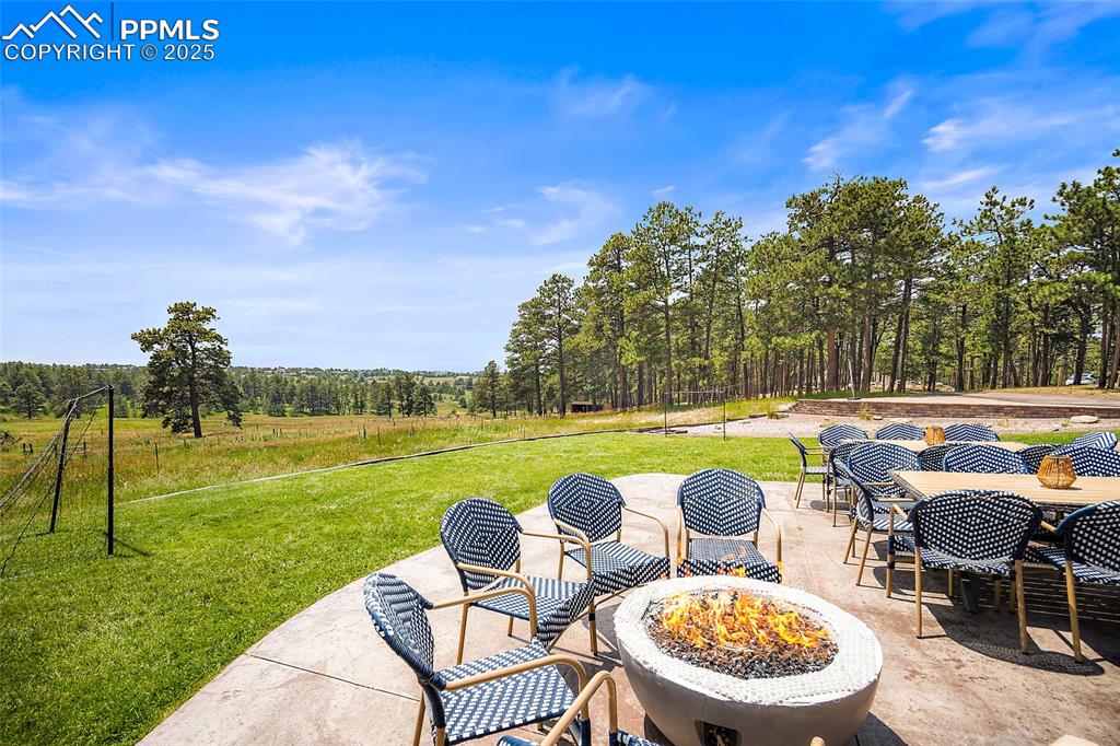 Image 42 of 47: View of patio with an outdoor fire pit and outdoor dining space