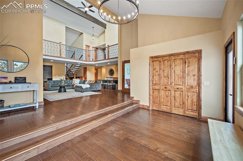 Image 6 of 47: Entryway featuring hardwood / wood-style floors, stairway, high vaulted cei