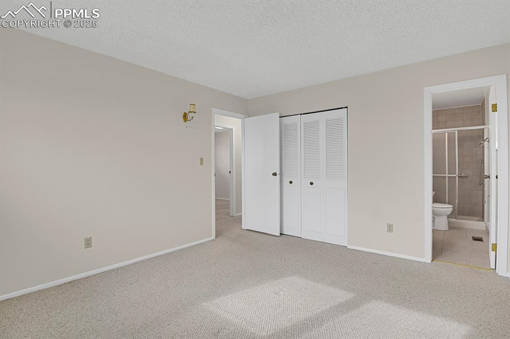 Image 20 of 45: Unfurnished bedroom featuring carpet floors, a textured ceiling, a closet,