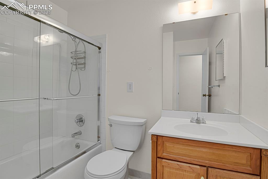 Image 24 of 45: Full bathroom featuring vanity and combined bath / shower with glass door