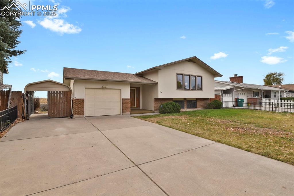 Image 3 of 45: Tri-level home with brick siding, an attached garage, driveway, roof with s