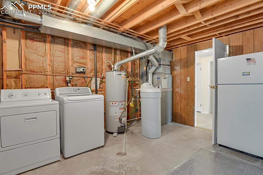 Image 37 of 45: Unfinished basement with freestanding refrigerator, gas water heater, indep