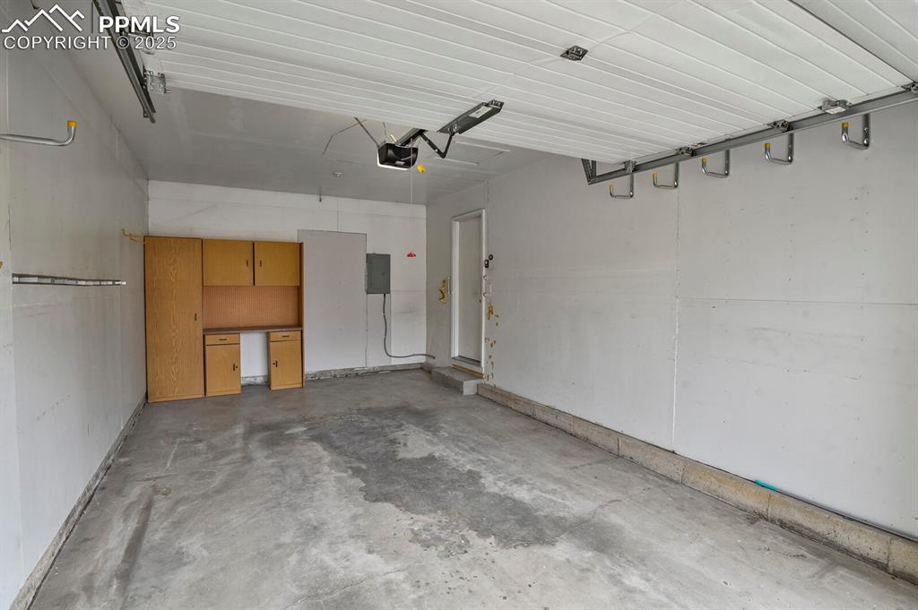 Image 38 of 45: Garage featuring electric panel and a garage door opener