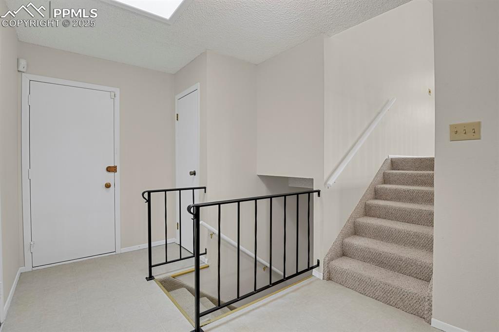 Image 5 of 45: Staircase with a textured ceiling and tile patterned floors