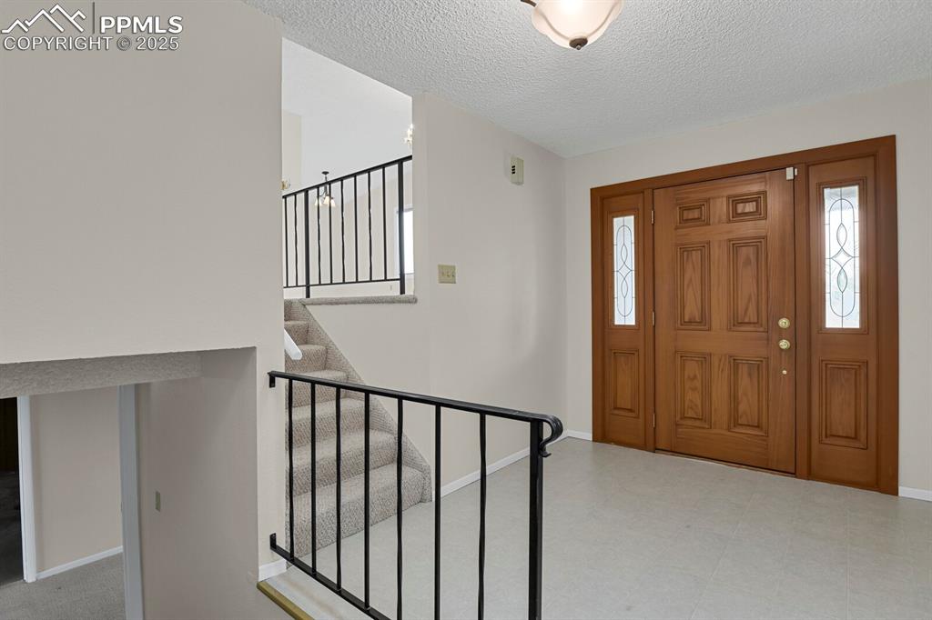 Image 6 of 45: Foyer with a textured ceiling and stairway
