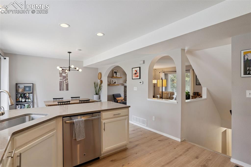 Image 11 of 40: Updated kitchen with stainless steel appliances, white cabinets, a peninsul