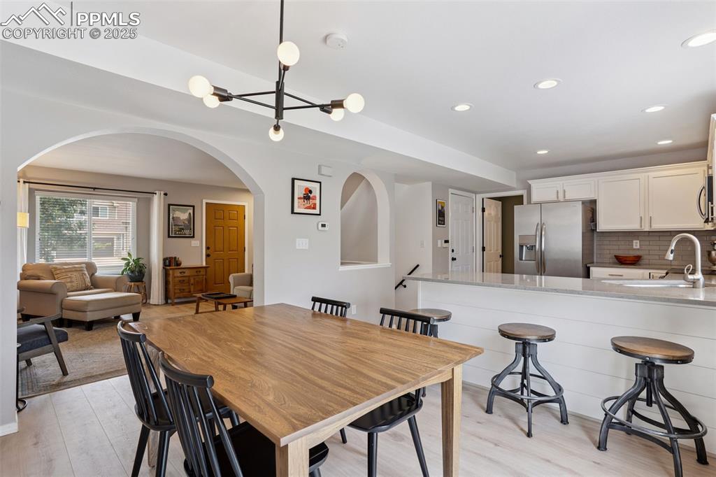 Image 14 of 40: Dining room featuring a chandelier and light LVP flooring with a sliding gl