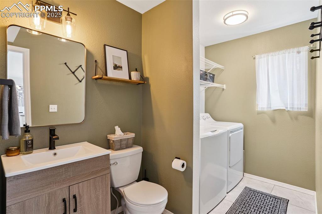 Image 15 of 40: Main-floor half bathroom with a laundry room attached.