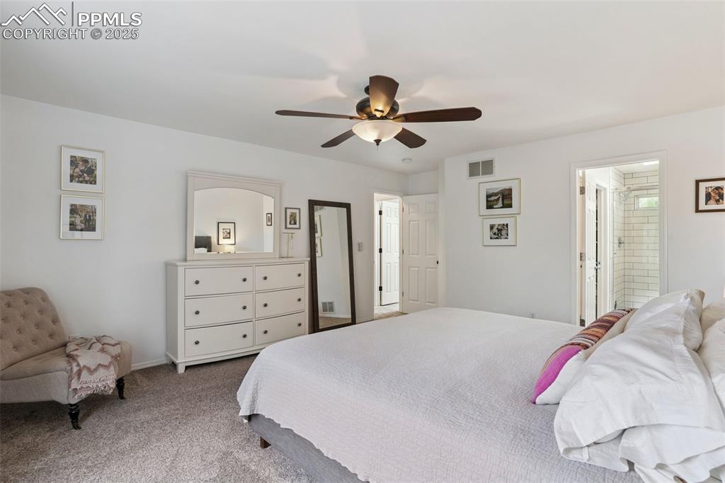 Image 18 of 40: Primary bedroom featuring carpet floors, ceiling fan, and ensuite bath