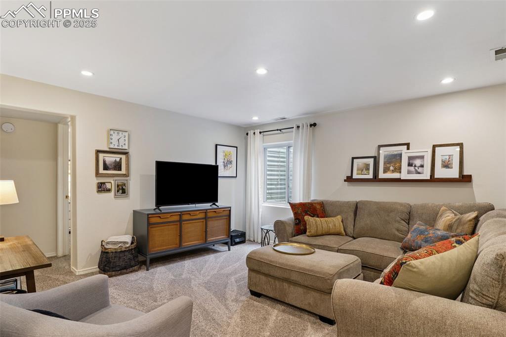 Image 27 of 40: Carpeted basement living room with recessed lighting