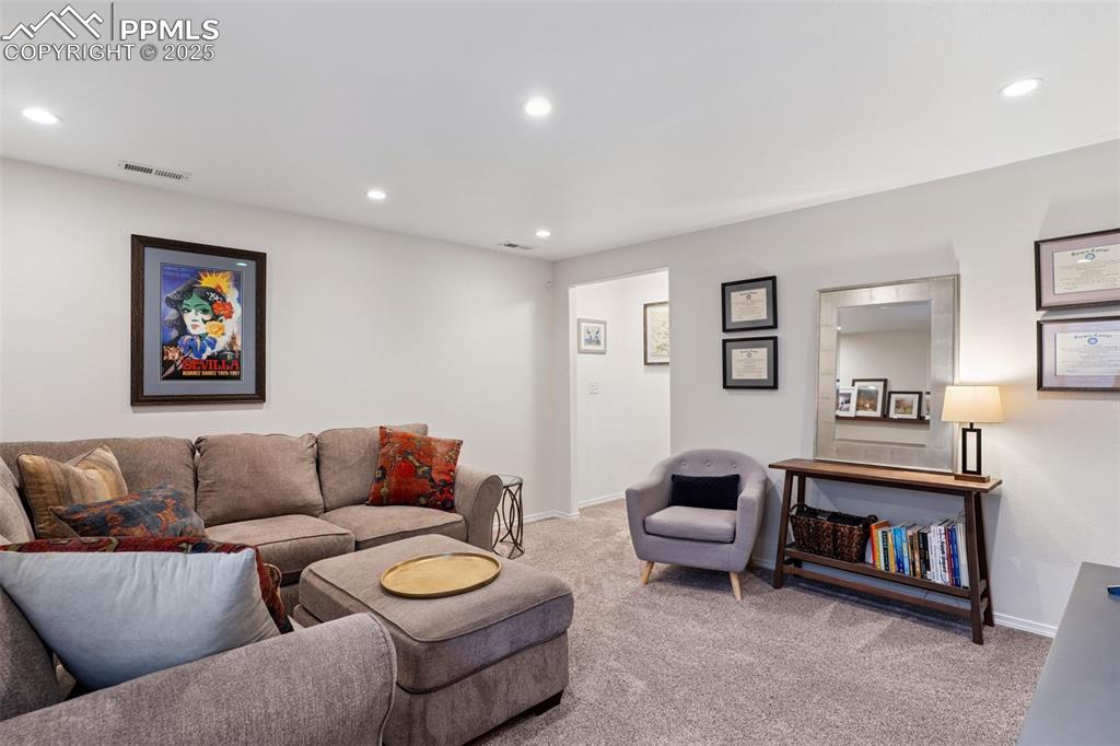 Image 28 of 40: Carpeted basement living room with recessed lighting