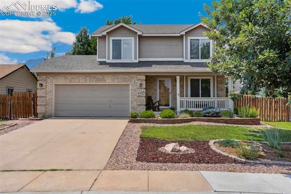 Image 3 of 40: View of front of home with covered porch and 2-car garage.