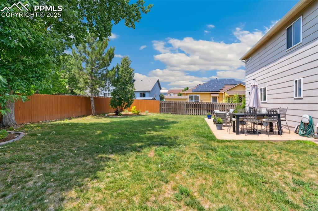 Image 33 of 40: Fenced backyard featuring mountain views, a patio and outdoor dining area