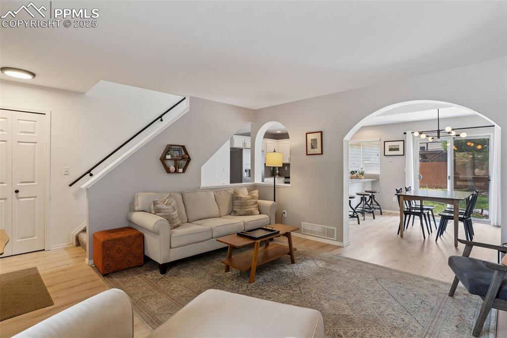 Image 7 of 40: Living area featuring arched walkways, light LVP, and a fireplace