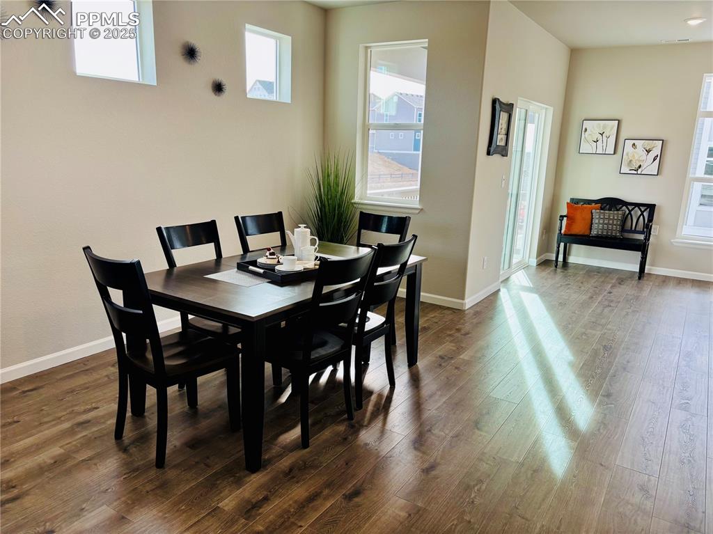 Image 6 of 11: Dining space with wood finished floors