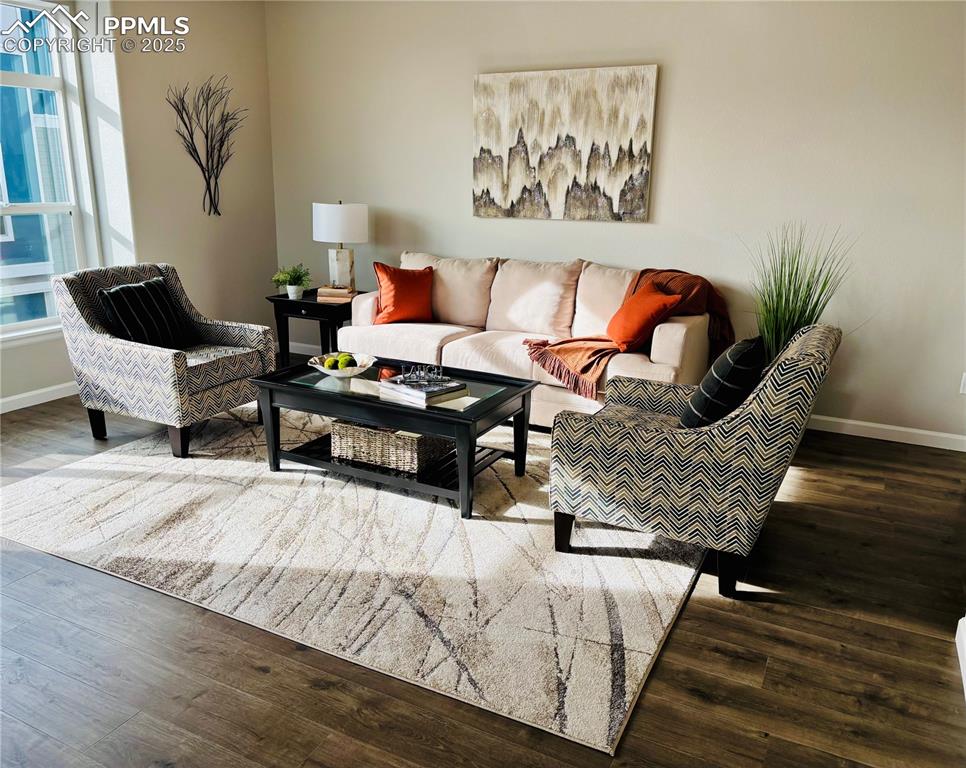 Image 7 of 11: Living area featuring wood finished floors and baseboards