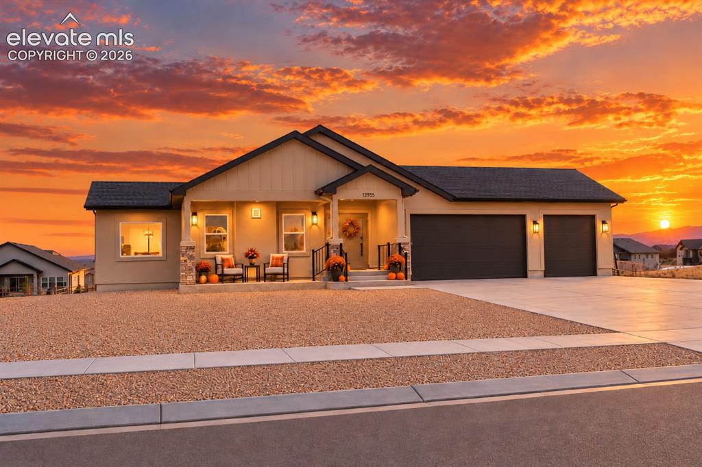 Caption: Contemporary single-story residence with a stucco exterior and dark-toned roof