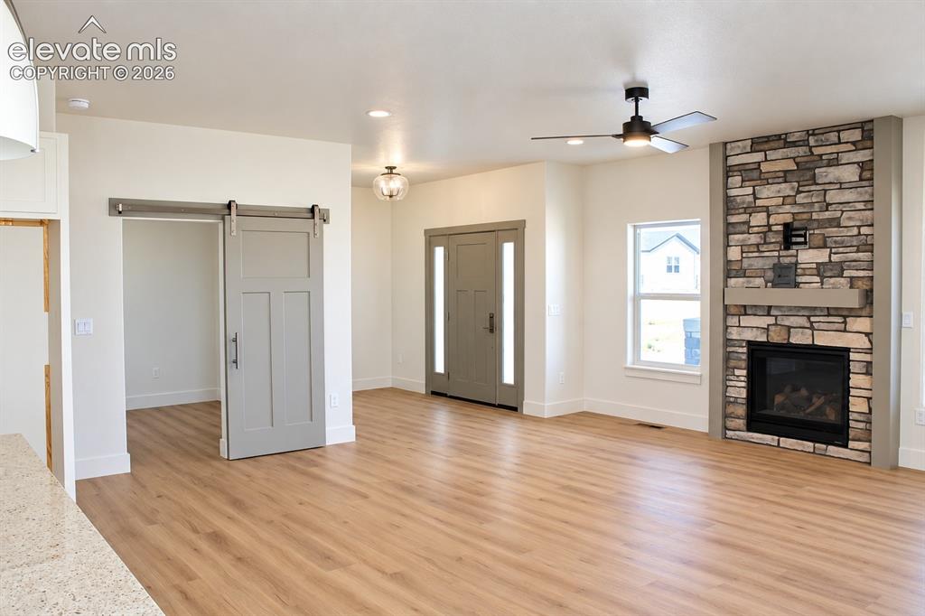 Image 10 of 44: Wood-finish flooring throughout, stone-clad corner fireplace with a built-i