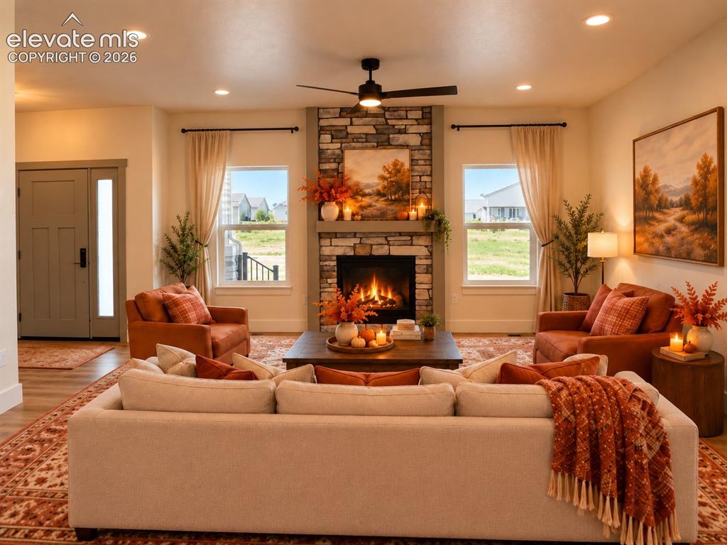 Image 11 of 44: Living area featuring a stone-clad fireplace, built-in recessed lighting, a