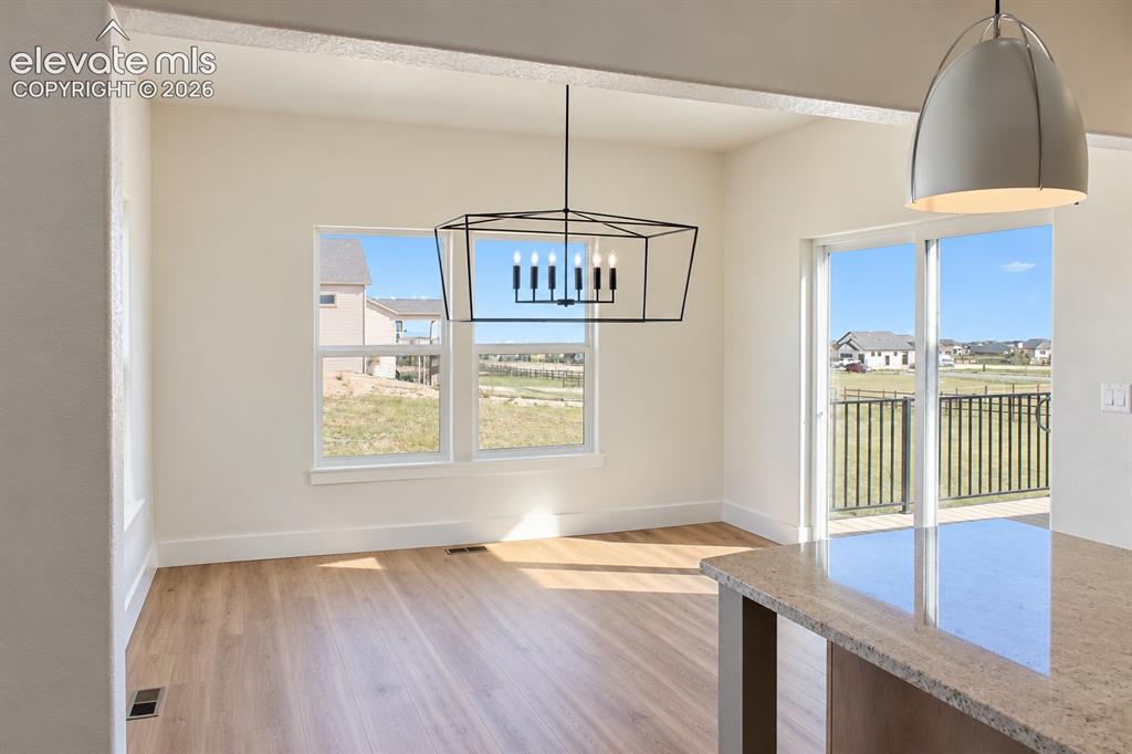 Image 16 of 44: Open floor plan with wood-finish flooring, a contemporary geometric chandel