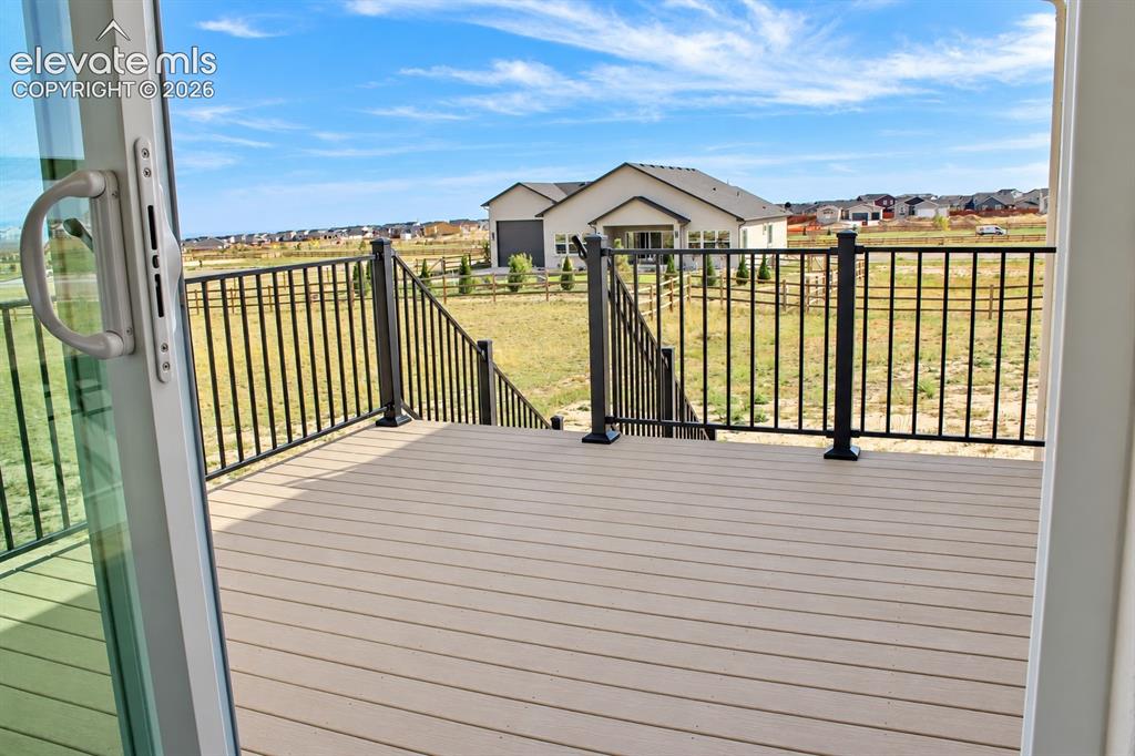 Image 18 of 44: Deck with composite decking, black metal railings, and integrated steps