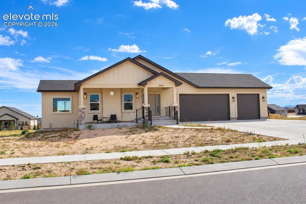 Image 2 of 44: Contemporary stucco exterior with a two-car garage, covered porch, and asph