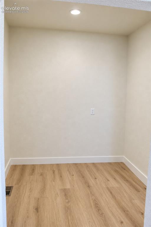 Image 22 of 44: Recessed ceiling light, neutral wall color, wood-finish flooring, white tri