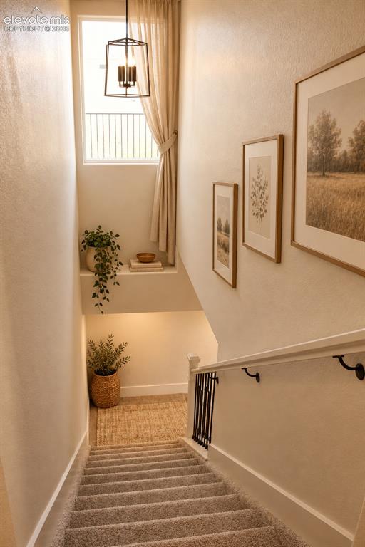 Image 23 of 44: Carpeted staircase featuring a window with natural light, a metal and wood 