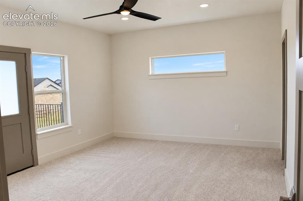 Image 26 of 44: Neutral-toned carpeting, recessed ceiling lighting, and a modern ceiling fa