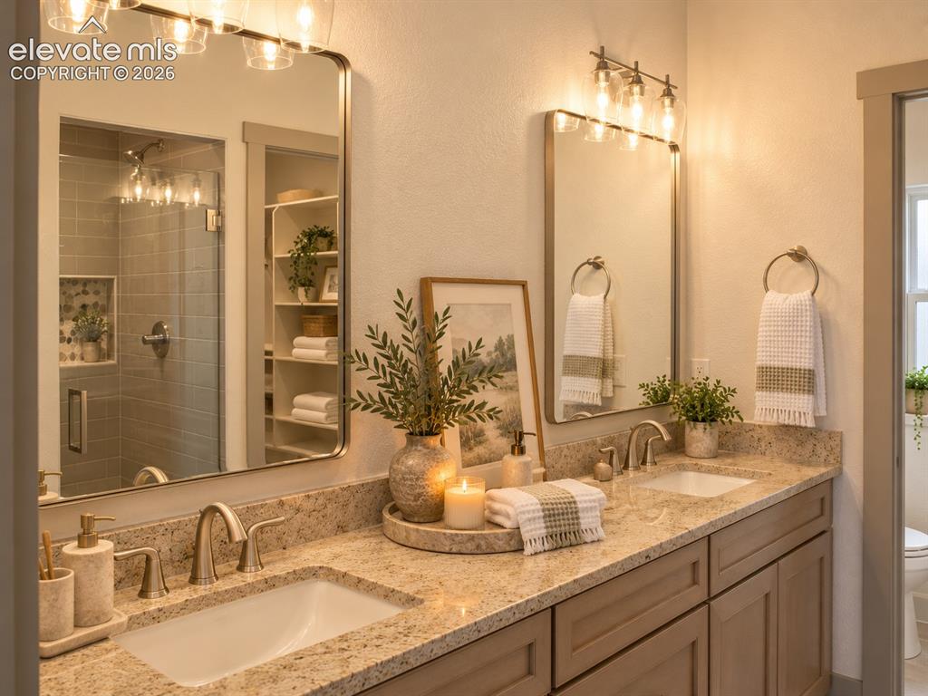 Image 27 of 44: Dual vanity with stone-finish countertops and undermount sinks, custom cabi